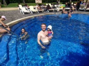 father holding baby in pool