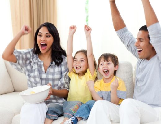 a family watching the best disney+ shows for families on the couch